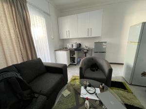 una sala de estar con un sofá y una silla en 94 Buren Street, en Welkom