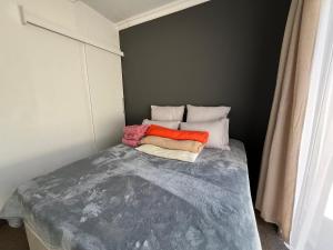 Un dormitorio pequeño con una cama con tres almohadas. en 94 Buren Street, en Welkom