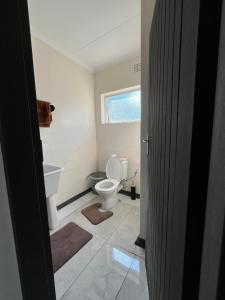 Un baño con inodoro y ventana. en 94 Buren Street, en Welkom