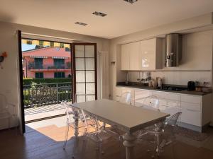 a kitchen with a table and chairs and a balcony at Ampio Appartamento con vista lago, sauna e camino Golf club Margara in Fubine