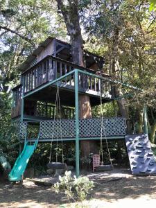 a tree house with a swing and a slide at YerbaBuena Lodge in Monteverde Costa Rica +28 photos