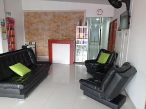 a living room with two black leather couches at Hotel el cable pereira in Pereira