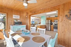 a dining room and kitchen with a white table and chairs at 8074 - Sea Glass Charmer in Avon