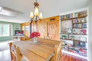 a dining room table with a vase of flowers on it at Treetop Hideaway with Lake Views and Fire Pit! in Fairfield Bay