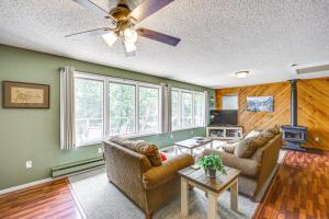 a living room with two couches and a tv at Treetop Hideaway with Lake Views and Fire Pit! in Fairfield Bay