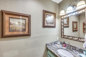 a bathroom with a sink and a mirror at Treetop Hideaway with Lake Views and Fire Pit! in Fairfield Bay +25 photos