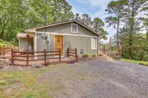 a small house with a porch and a fence at Treetop Hideaway with Lake Views and Fire Pit! in Fairfield Bay