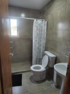 a bathroom with a toilet and a shower and a sink at OMA Departamentos por día -2 in Utracán