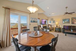 a dining room and living room with a wooden table at CP100A - Sound Sunset in Kill Devil Hills +41 photos