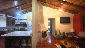 a kitchen with a fireplace and a living room at Casa tipo Chalet en el pasochoa 