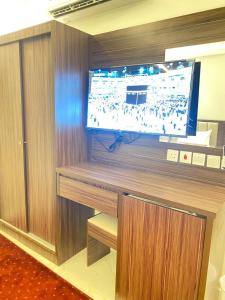 a large flat screen tv on a wooden wall at فندق منازل روز in Al Lith