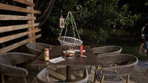 a wooden table with chairs and a bowl of food on it at Borsh Selavi Guest House in Borsh