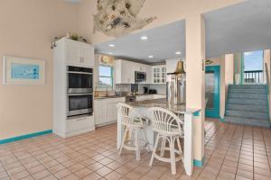 una cocina con armarios blancos y una isla con taburetes en 8403 - Lady of Dare, en Avon