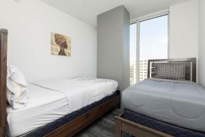 a bedroom with two beds and a large window at Stunning 3BR High Rise Pool, Spa & Rooftop Views in Los Angeles +26 photos