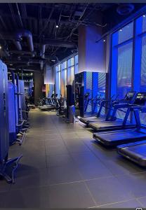 a gym with rows of exercise equipment and windows at Stunning 3BR High Rise Pool, Spa & Rooftop Views in Los Angeles