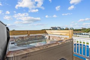 a hot tub on the deck of a house at 8478 - Seas the Breeze II in Avon