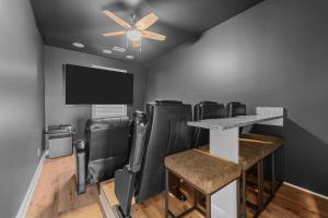 a bar with black leather chairs and a flat screen tv at 8477 - Seas the Breeze I in Avon