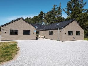 a large house with a garage on a gravel driveway at 5 star holiday home in Rømø in Kongsmark