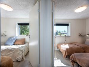 a bedroom with two beds and two windows at 5 star holiday home in Rømø in Kongsmark +33 photos