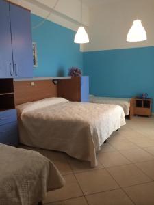 um quarto com 2 camas e uma parede azul em EuroHotel em Cesenatico
