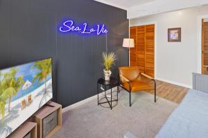 a living room with a tv and a chair at 8205 - Sea La Vie Salvo in Waves