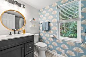 a bathroom with a toilet and a sink and a mirror at Casa Madeore Luxury Bungalow in St. Augustine +37 photos