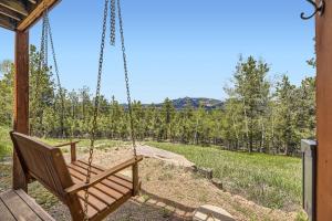 a swing in the porch of a cabin with a view at Pine Cabin home in Pine +34 photos