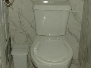 a bathroom with a white toilet and a trash can at Tiny House Rio in Rio de Janeiro +35 photos