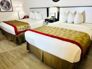 a hotel room with two beds and a desk at Ramada by Wyndham Birmingham Airport in Birmingham