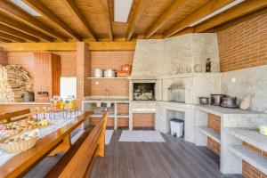 una grande cucina con un lungo tavolo e un camino di Casa Ar-Belo by House and People 