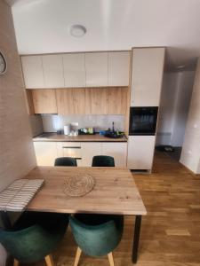 a kitchen with a wooden table and some chairs at Vila#Borova#800m in Zlatibor +4 photos