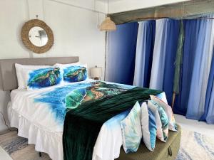 um quarto com uma cama grande e cortinas azuis em Turtle Nest Mayreau em Mayreau