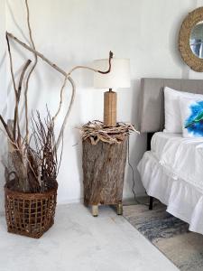 um quarto com uma cama e uma mesa com um abajur em Turtle Nest Mayreau em Mayreau
