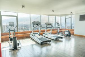 a gym with several treadmills in a room with windows at Hotel Terrado Cavancha in Iquique