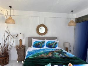 um quarto com uma cama grande com travesseiros azuis em Turtle Nest Mayreau em Mayreau