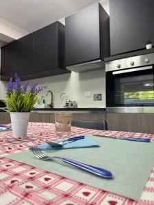 una cocina con mesa con tenedor y cuchillo en Welcome Love, en Acilia