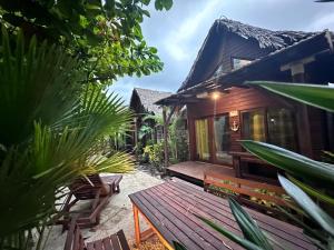 a wooden house with a bench in front of it at Cabañas kai in Iztapa