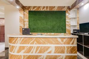 an office with a desk with a green wall at Hotel O White House in Patna