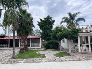 a house with two palm trees in front of it at 3 Marías in Silao