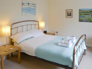 a bedroom with a large bed with towels on it at Teal Cottage in Embleton
