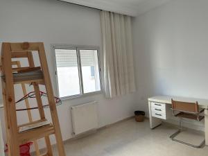 a room with a ladder and a desk and window at Single Room downtown La Marsa- Near the Sea in La Marsa +4 photos