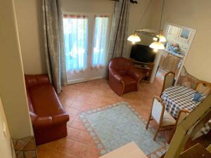 a living room with a couch chair and a television at Holiday home in Balatonmariafürdo 54665 in Balatonmáriafürdő