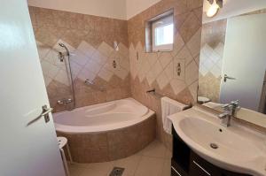 a bathroom with a tub and a sink at Holiday home in Balatonmariafürdo 54665 in Balatonmáriafürdő +15 photos