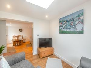 a living room with a couch and a flat screen tv at The Sail Loft in Teignmouth