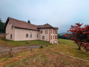 ein großes Haus auf einem Feld in der Unterkunft Chambre Iris dans bâtisse rénovée au cœur de la nature - FR-1-589-726 in Moyenmoutier