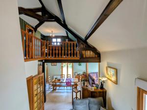 ein Wohnzimmer mit einer Holzdecke und einer Treppe in der Unterkunft Chambre spacieuse avec piscine, spa et hammam - FR-1-589-721 in Anould