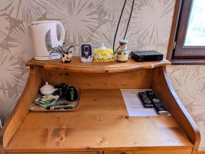 ein Holzregal mit einer Kaffeemaschine und anderen Gegenständen darauf in der Unterkunft Chambre familiale avec piscine et SPA à Anould - FR-1-589-708 in Anould