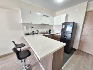 a kitchen with a white counter and a refrigerator at Departamento en San Isidro in Lima