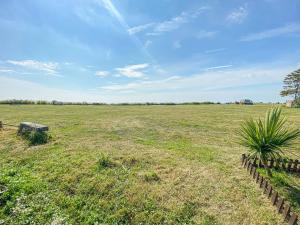 ein großes offenes Feld mit einem Zaun in der Mitte in der Unterkunft Pakefield Seaview Cottage in Lowestoft