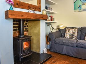ein Wohnzimmer mit Kamin und Couch in der Unterkunft Pakefield Seaview Cottage in Lowestoft